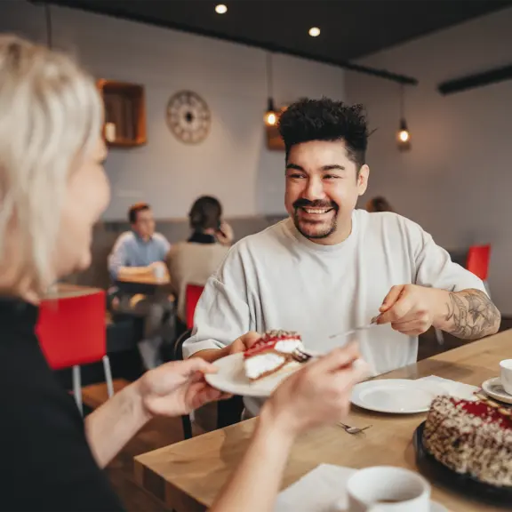 Person reicht Stück Torte